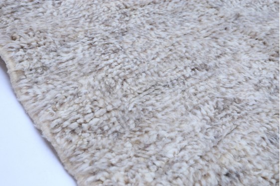 "Soft grey handwoven Moroccan Beni Ourain rug with distinctive fringe detail"