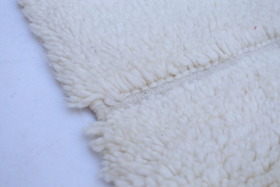 Minimalist Beni Ourain wool rug with a grid pattern and plush texture.